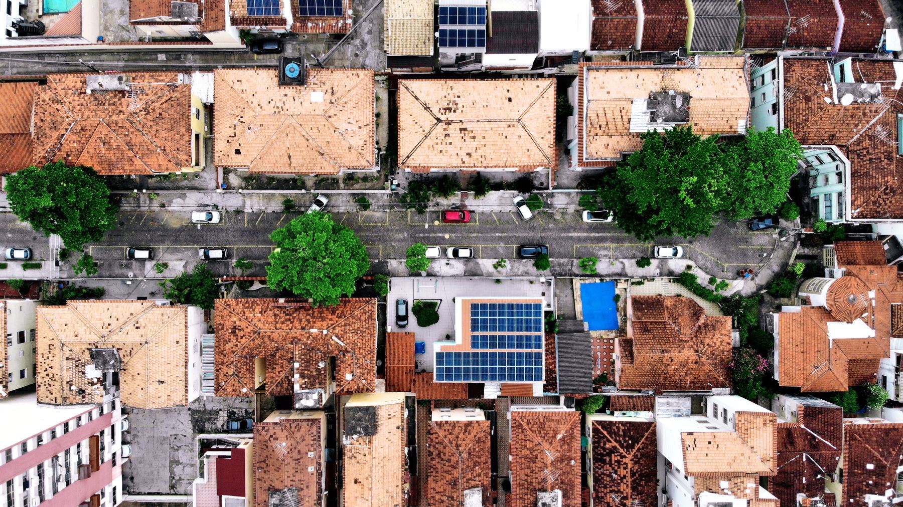 Vista cenital de techos planos de concreto con paneles solares en un barrio urbano